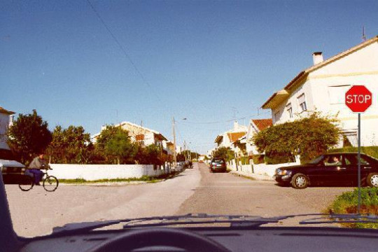 Nesta situação, o velocípede e o automóvel preto devem ceder passagem?